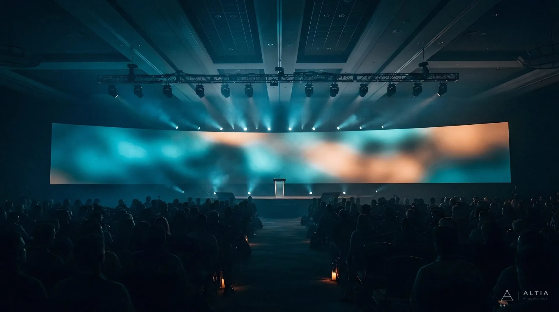 Convención en un auditorio con pantalla LED panorámica y haces de luz